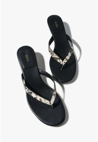 Fekete papucs vékony, kígyóbőr mintás pánttal és lapos talppal. A pántok V alakot formálnak, finom fémes díszítésekkel.