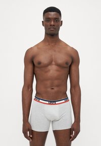Szürke, pamut boxer alsónadrág kék, fehér és piros gumis derekkal, amelyen a "Levi's" logo látható. Egyszerű, testhezálló kialakítás, minta nélkül.