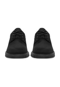 O pereche de pantofi din piele neagră cu șireturi, având talpă din cauciuc rezistentă, văzuți din față pe un fundal alb.