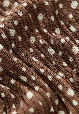 Brown knit fabric featuring white polka dots in various sizes, with a textured surface and ribbed design throughout.
