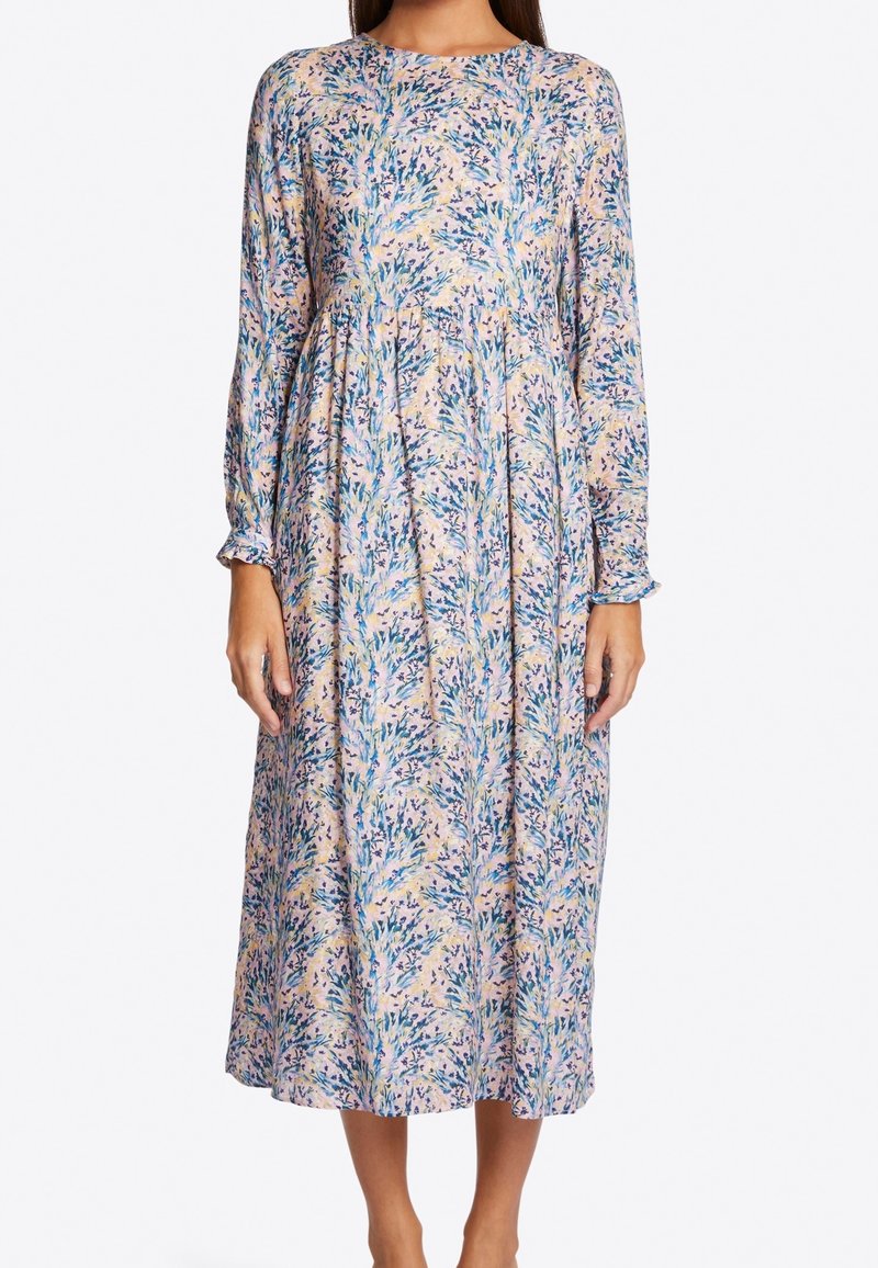 Vestido de estampado floral con mangas largas, escote redondo y cintura fruncida. Tela ligera en colores pastel, con patrones botánicos en azul y amarillo.