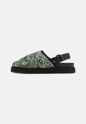 Grøn og sort polstret slidesandal med hvid paisleyprint, justerbar hælrem og tyk sort sål, vist fra siden.