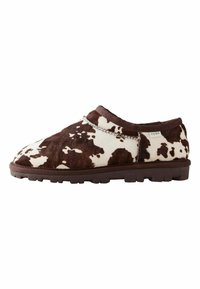 Pantofi slip-on cu imprimeu de vacă maro și alb, cu o textură moale, talpă din cauciuc și detalii cusute de-a lungul marginii superioare.