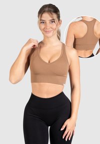 Bruine geribbelde sportbeha met een diepe V-halslijn en racerback ontwerp. Soepele textuur met subtiele stiksels. Zwarte high-waisted leggings.
