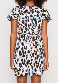 Robe à manches courtes avec un fond rose et un imprimé léopard noir, bleu et jaune, dotée d'une ceinture à nouer à la taille.