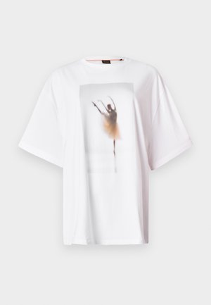 Vit oversize t-shirt gjord av bomull, med en suddig grafik av en balettdansös i en elfenbensvit tutu på framsidan.