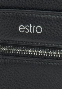 Černá kožená peněženka s texturovaným povrchem, s stříbrným zipem a značkou "estro" vyraženou na přední straně.