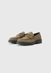 Mocasini maro din suede, cu vârf rotund, având un clapet simplu în față, cu talpă din cauciuc negru cu textură antiderapantă și un mic accent cu logo.