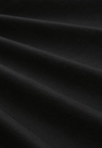 Musta puuvillakangas, jossa on sileä pinta, sisältäen hienovaraisia poimuja ja tasainen ulkonäkö, ihanteellinen erilaisiin vaatekäyttöihin.