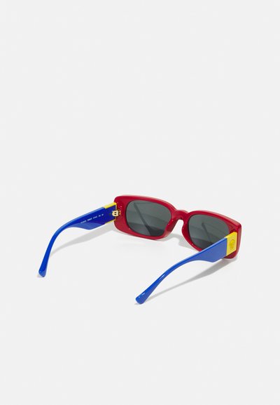 Red rectangular sunglasses with dark lenses, blue arms featuring a yellow logo accent, and a glossy finish.