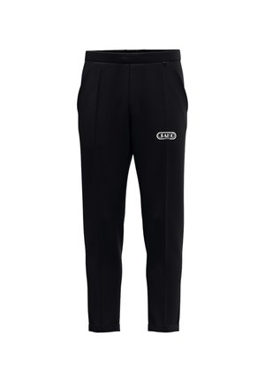 Zwarte slim fit broek met zijzakken en een wit JAKO-logo op de rechterdij tegen een witte achtergrond.