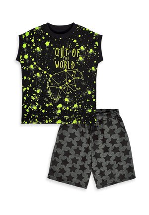 Schwarzes ärmelloses Shirt mit neongrünen Spritzern, "Out of the World" Schriftzug, Bärensternbild-Grafik, kombiniert mit grauen Shorts mit Sternenmuster.