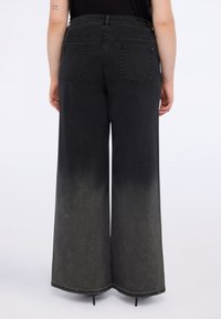 Vaatteet leveälahkeiset farkut, jotka ovat tummista vaaleisiin harmaisiin. Niissä on takataskut ja siisti helma. Valmistettu pehmeästä denimmateriaalista.