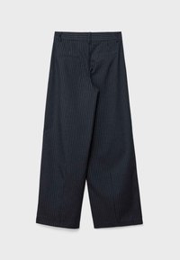 Pantalons noirs à jambes larges avec des rayures verticales blanches. Comprend deux poches arrière et un design ajusté. Texture de tissu lisse.