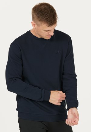 Marineblå sweatshirt med rund hals, ribbede manchetter og kant. Har et diskret præget FZ-logo på brystet. Glat tekstur, almindelig pasform.