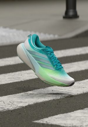 Lahka tekaška čevelj z zgornjim delom v turkiznem prelivu, belim srednjim podplatom in teksturiranim podplatom. Na strani ima dizajn s tremi črtami.