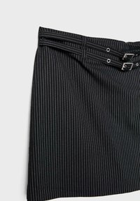 Crna mini suknja s vertikalnim bijelim prugama, petljama za pojas i dva srebrna kopčana detalja na teksturiranom materijalu. Ima klasičan dizajn.