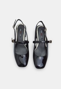 Fekete lakkbőr slingback cipők négyzet alakú orral, vékony bokapánttal és kis négyzet alakú csattal a pánton.