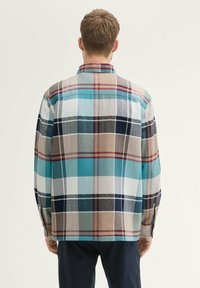 Kariertes Flanellhemd mit einer Mischung aus türkis, Marineblau, Braun und weißen Quadraten; weiche Textur, geknöpfte Manschetten und klassischer Kragen.