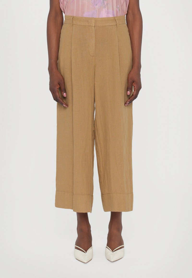 Brown wide-leg trousers with a textured finish, featuring a high waist and pleat detailing. Hem is folded for added dimension.