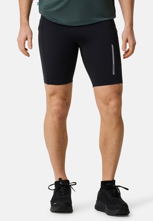 Black athletic shorts made of stretchy material, featuring a fitted design, with a reflective stripe on the side and smooth texture.