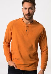 Oranje langdragige Henley-shirt van ribstof, met een ronde halslijn, een placket met twee knopen en aansluitende mouwen.
