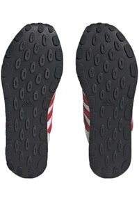 Schwarze Gummisohlen mit kreisförmigem Muster, ausgestattet mit drei rot-weißen diagonalen Streifen an den Seiten, gekennzeichnet mit einem Logo.