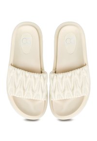Beige skandinaviske sandaler med en tekstureret, quiltet rem og glat sål. Udstyret med et logo på indersålen, designet for komfort og stil.