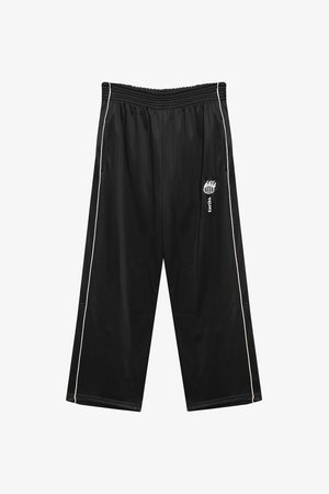 Mustad must spordipüksid, millel on pingevaba lõige, Elastne talje ja valged külgtriibud. Alumises sääreosas on leeklogo.