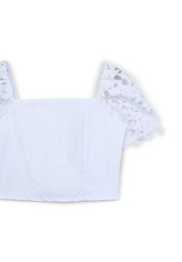 Top blanc court avec décolleté carré et manches courtes bouffantes en tissu en dentelle florale.