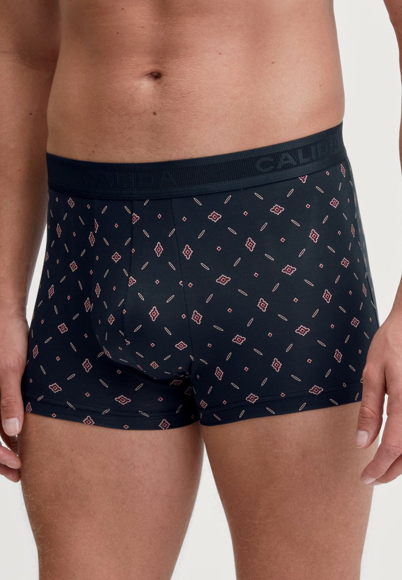 Fitted black boxer briefs with a patterned design in red and cream. Features a branded elastic waistband for secure fit. Soft material.