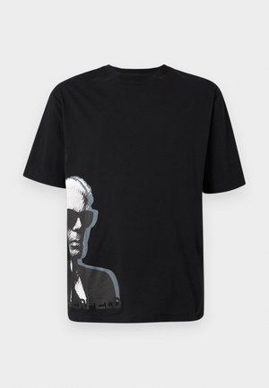 T-shirt noir à manches courtes avec un graphique en niveaux de gris d'un homme portant des lunettes de soleil sur le côté inférieur gauche.