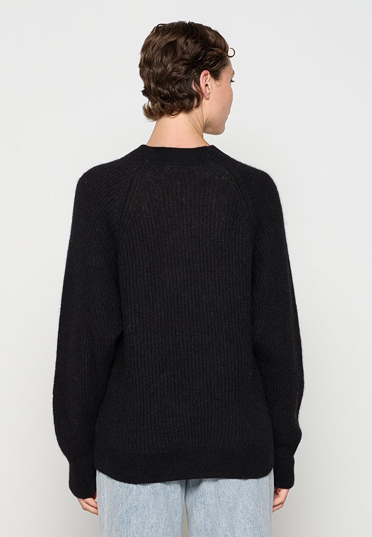 Schwarzer Strickpullover mit gerippter Struktur, runder Halslinie und überschnittenen Schultern. Besitzt eine lockere Passform und einfarbiges Design.