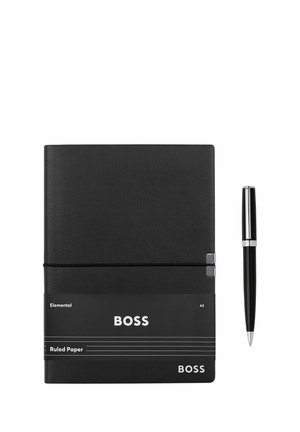 Czarny notatnik formatu A5 w linię z napisem "BOSS" oraz czarny długopis z srebrnymi detalami obok niego na białym tle.