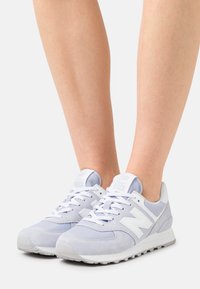 Ljuslila New Balance 574-sneakers i mesh och mocka med vita detaljer, vadderad plös och texturerade sulor.