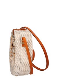Borsa tonda intrecciata in paglia bianca, con una superficie texture e una tracolla in pelle marrone chiaro. Decorata con accenti di conchiglie.