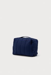 Ναυτικό μπλε ορθογώνια τσάντα καλλυντικών με επένδυση, με λαβή στην κορυφή και πλευρικό φερμουάρ σε λευκό φόντο.