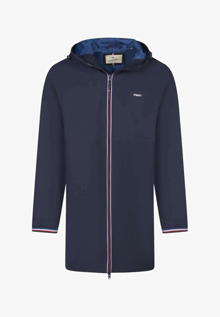 Veste longue à capuche bleu marine avec fermeture éclair sur le devant, petit logo blanc sur la poitrine et bordures rouge-blanc-bleu aux poignets et aux bords de la fermeture éclair.