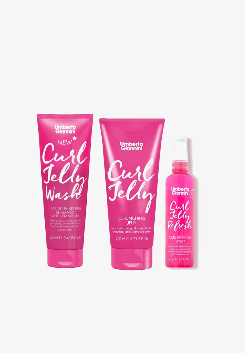 Trois produits de soin capillaire rose : shampooing, gel frisant et spray revitalisant pour boucles. Du texte blanc en gras sur chaque tube met en avant les principaux avantages.