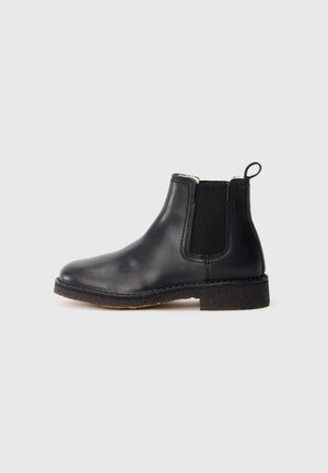 Black leather Chelsea boot with elastic side panels, pull tab at heel, and textured rubber sole against a plain grey background.