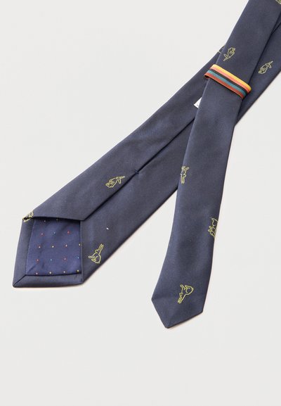 Corbata azul marino con pequeñas ilustraciones de conejos amarillos, lazo de corbata con rayas multicolores y forro azul marino con lunares multicolores.