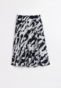 Falda de diseño en blanco y negro con un tejido suave, que presenta pliegues y una forma acampanada. El diseño incluye patrones abstractos y ondulados.
