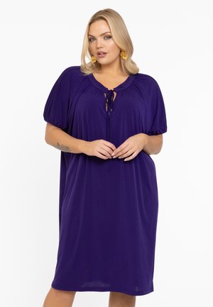 Lila Kleid aus weichem Stoff, mit lockerer Passform, kurzen Puffärmeln, rundem Halsausschnitt und einer Schleifendetail vorne.