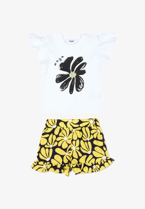 Top bianco a maniche corte con stampa di fiori neri e maniche arricciate abbinato a pantaloncini blu navy con motivi floreali gialli e orli arricciati.