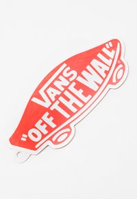 Vans márkájú, piros, skateboard formájú címke, fehér szöveggel "OFF THE WALL" és "VANS", fényes felülettel és kivágott részlettel.