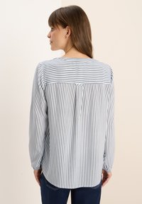 Chemise à rayures à manches longues en bleu et blanc, avec un pli au dos, un col rond et des poignets élastiques. Tissu léger, coupe décontractée.