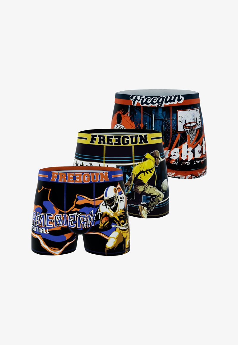 Trois paires de shorts de sport avec des graphiques audacieux. Les couleurs comprennent le noir, le jaune, le bleu et le rouge, avec des illustrations d'actions sportives et des logos.