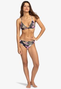 Bikini-set med svart bas som har rosa och beige blomster mönster. Justerbara band, en triangulär topp och klassiska byxor.