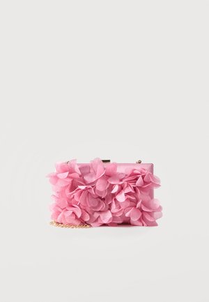 Kleine rechteckige rosa Clutch-Tasche, verziert mit mehrlagigen Stoffblumen und einem goldenen Kettenriemen auf weißem Hintergrund.