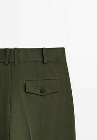 Ceinture de pantalon vert foncé avec trois passants de ceinture et une poche à rabat boutonnée à l'arrière droite.